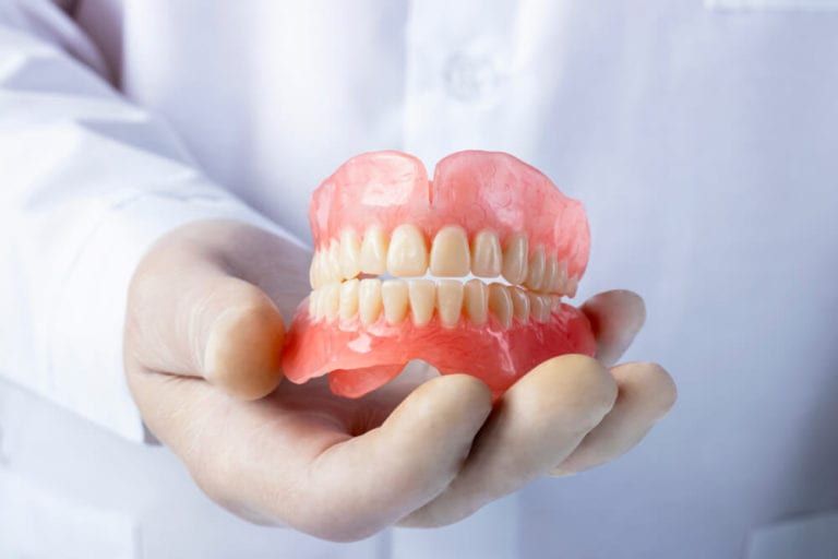 dentist holding dentures