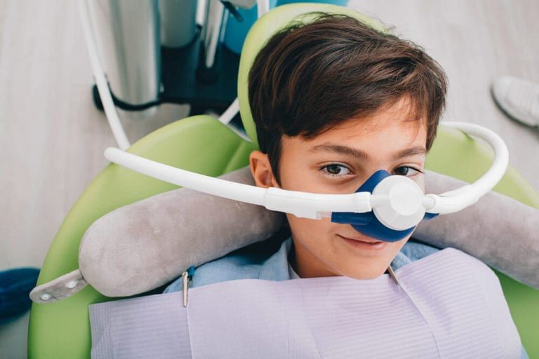 child waiting for dental work with sedative mask