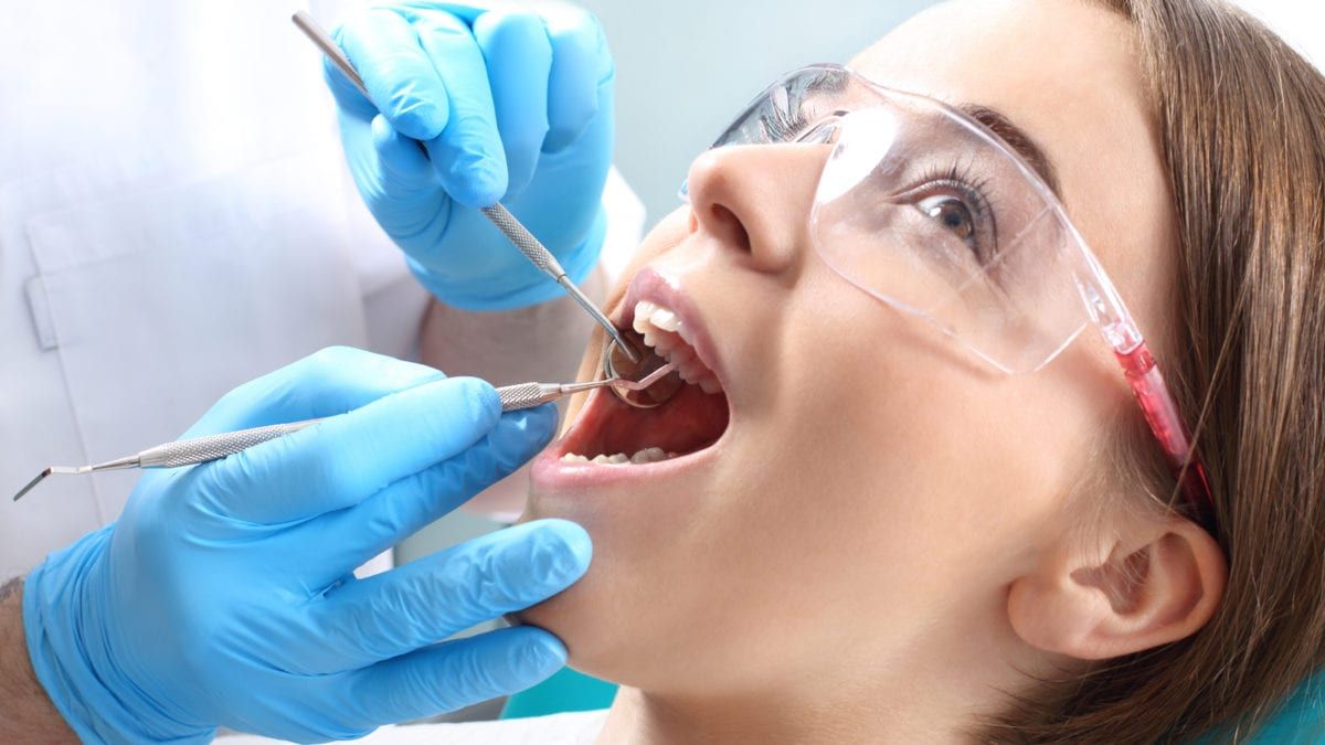 Dentist inspecting patients mouth