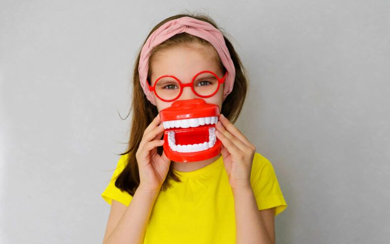 Child Holding Up Tooth Model