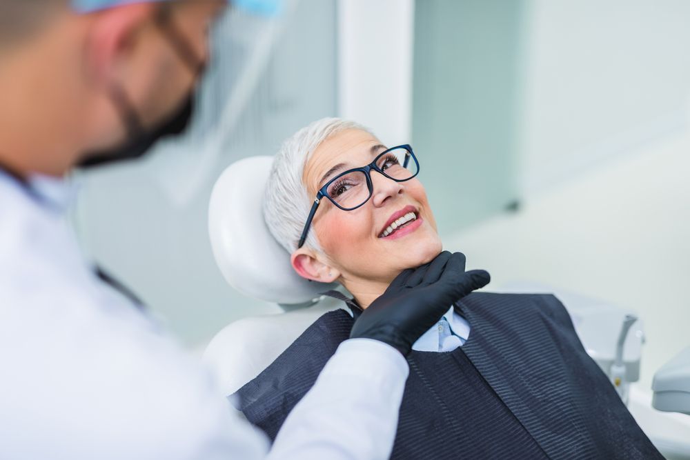 A dentist speaking with a patient about Hybrid Dentures