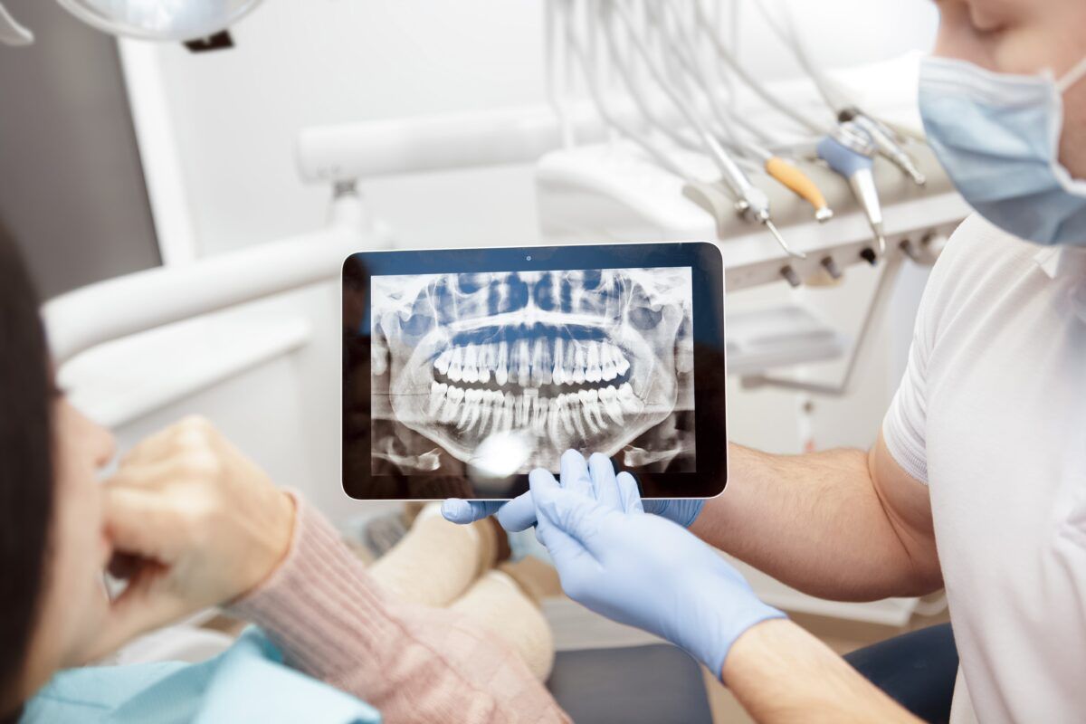 dentist reviewing digital dental xray with patient on tablet